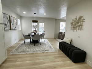 Dining space with a textured ceiling, light wood finished floors, plenty of natural light, and recessed lighting