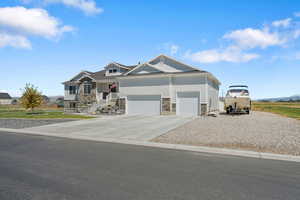 Craftsman house with stone siding, concrete driveway, an attached garage, and board and batten siding