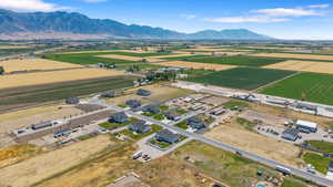 Aerial view of sparsely populated area featuring a mountainous background and abundant farmland