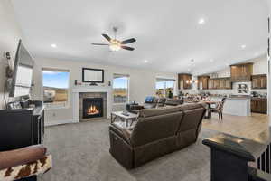 Living room featuring healthy amount of natural light, a tile fireplace, recessed lighting, a ceiling fan, and light carpet