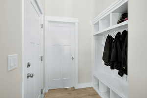 Mudroom with light wood-style floors and baseboards