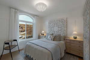 Bedroom with a decorative wall and wood finished floors