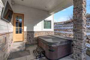 View of patio with entry steps and a hot tub