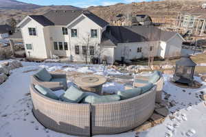 Snow covered patio featuring a mountain view, a patio area, a fire pit, and area for grilling