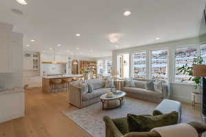 Living area with light wood-style floors and recessed lighting