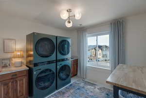 Laundry room with estacked washer and dryer and light tile patterned floors