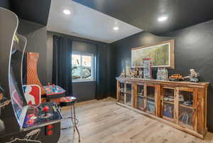 Game room with light wood-style floors and recessed lighting