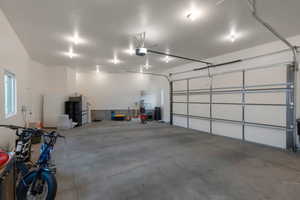 Garage featuring freestanding refrigerator and a garage door opener