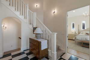 Staircase featuring a chandelier and baseboards
