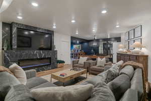 Living area featuring wood finished floors, a fireplace, and recessed lighting