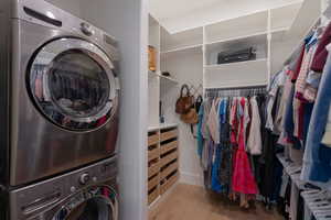 Laundry room featuring stacked washer / drying machine and light wood finished floors