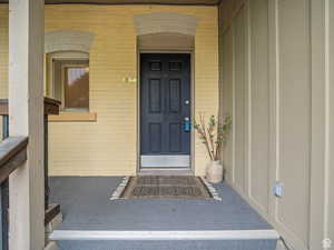 Property entrance with brick siding and a porch