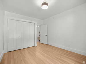 Unfurnished bedroom featuring light wood finished floors and a closet