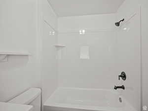 Bathroom featuring shower / washtub combination and toilet