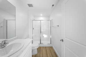 Bathroom with a stall shower, vanity, and light wood-style flooring