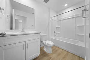Bathroom with vanity, shower / bath combination, and light wood finished floors