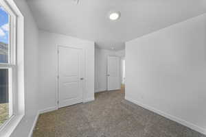 Unfurnished bedroom with carpet and baseboards