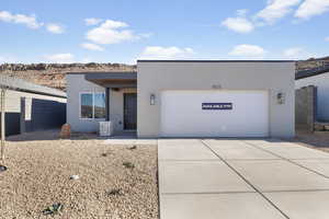 Modern home featuring stucco siding, driveway, and an attached garage
