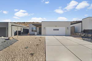 All photos are of a similar property.  View of front of property featuring stucco siding, driveway, and a garage