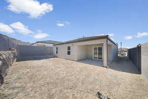 Back of property featuring a fenced backyard, a patio area, and stucco siding