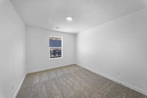 Carpeted spare room with baseboards