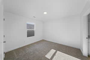 Empty room featuring baseboards and carpet