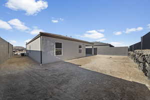 Back of property with a fenced backyard, a patio, and stucco siding