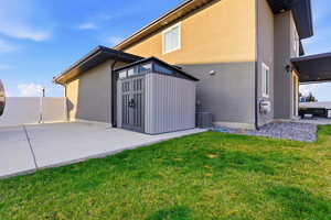 Rear view of property featuring stucco siding and a storage shed