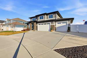 View of front of house with concrete driveway, a gate, and a garage