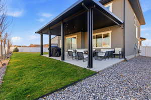 Back of house featuring a fenced backyard, a patio, an outdoor hangout area, and stucco siding