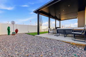 Fenced backyard with outdoor lounge area and a patio