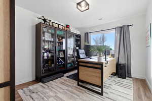 Office space with baseboards and light wood-type flooring