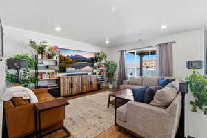Living area featuring wood finished floors, recessed lighting, and a textured ceiling