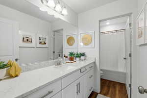 Bathroom with vanity, dark wood-type flooring, and shower / bathtub combination with curtain