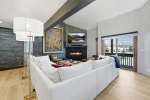 Living room featuring a large fireplace, light wood-style floors, and an accent wall