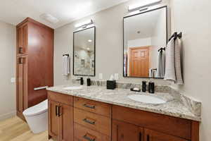 Bathroom featuring double vanity and light wood finished floors