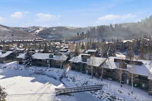 Snowy aerial view featuring a residential view and a mountain view