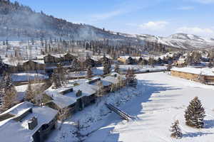 Snowy aerial view featuring a mountain view and a residential view