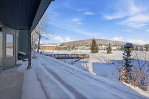 Yard layered in snow featuring a mountain view