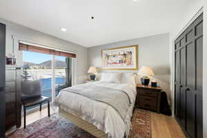 Bedroom featuring light wood-style flooring, access to outside, a mountain view, a closet, and recessed lighting