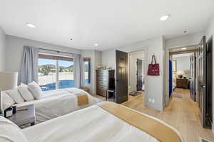 Bedroom featuring access to exterior, light wood-type flooring, and recessed lighting