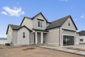 View of front of property featuring board and batten siding, roof with shingles, and stone siding