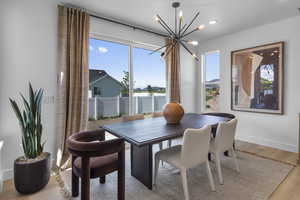 Dining space with light wood-style flooring, a chandelier, and recessed lighting