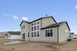 Rear view of house featuring stucco siding, a mountain view, and entry steps