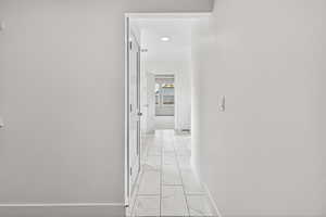 Hallway featuring baseboards and light marble finish flooring