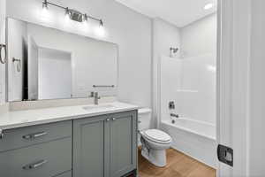 Full bathroom with shower / tub combination, vanity, light wood-style floors, and recessed lighting
