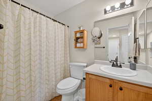 Bathroom with a shower with shower curtain, vanity, and a textured wall