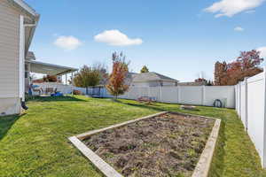 Fenced backyard featuring a garden and a patio area