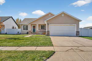 View of front facade featuring covered porch, brick siding, driveway, and an attached garage