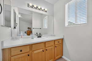 Bathroom featuring vanity, healthy amount of natural light, and a textured wall